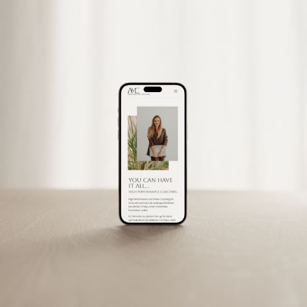 Anna-Martins-Coaching-Mockup-mobil Ein Handy steht auf einem hellen Holztisch. Auf dem Handy wird die WordPress Website von Anna Martins Coaching.