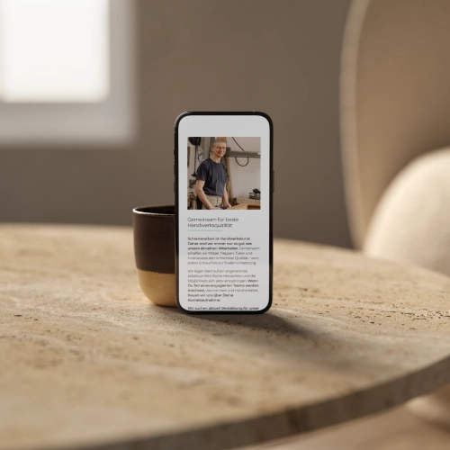 SchreinereiRieder-Website-neu-012 Laptop auf einer hellen Couch mit der geöffneten WordPress Website der Ferienwohnungen im Haus zum Wappen in Reifferscheid (Hellenthal, NRW), die ein modernes WordPress Webdesign mit Divi zeigt.